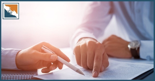 Hands of an attorney with reviewing a document with a client