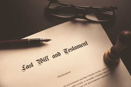 A last will and testament with an ink pen and glasses.