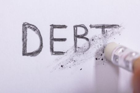 Word "debt" written in pencil and being erased