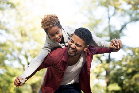 Daughter riding on her father's shoulders